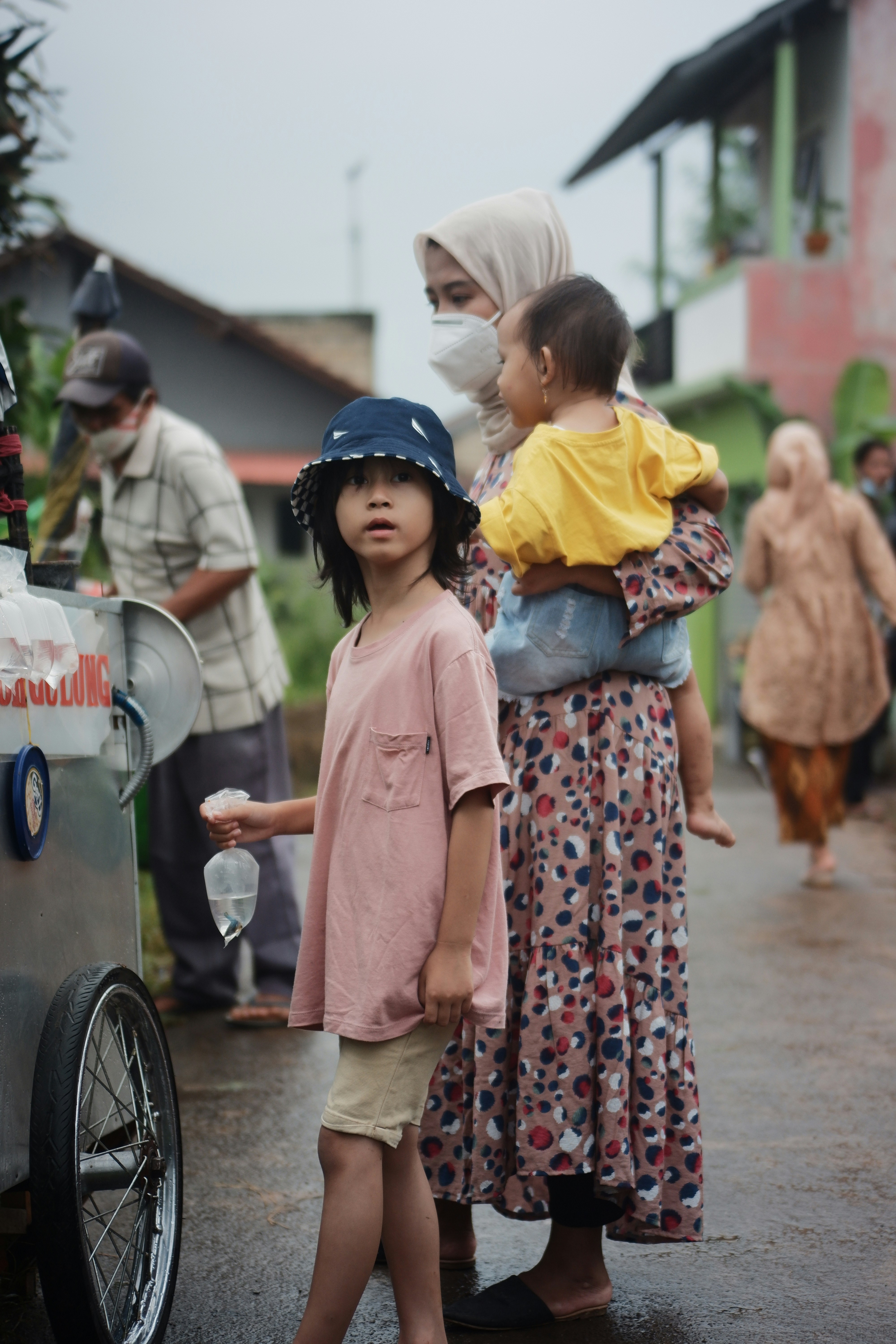 woman in pink dress standing beside woman in red and white floral dress