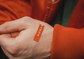 orange and white textile on persons hand