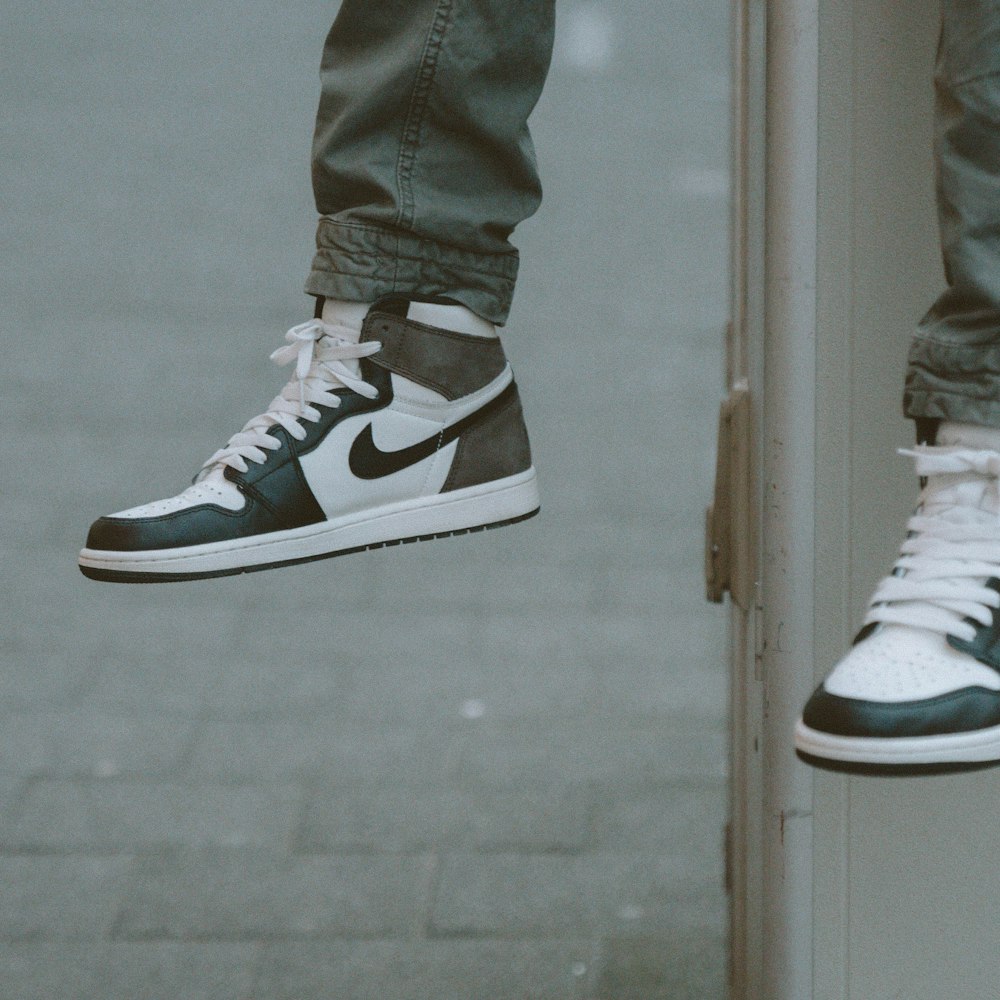 person in gray denim jeans and black and white nike sneakers