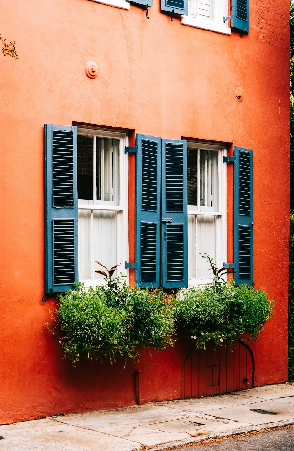 blue wooden window on red concrete building