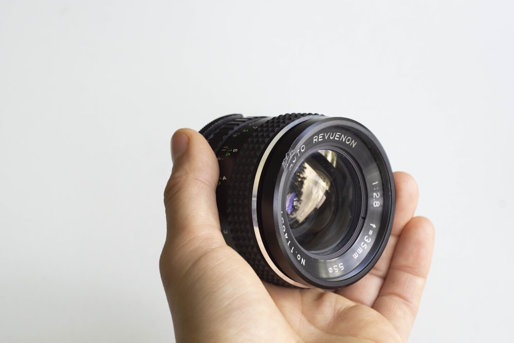 person holding black camera lens