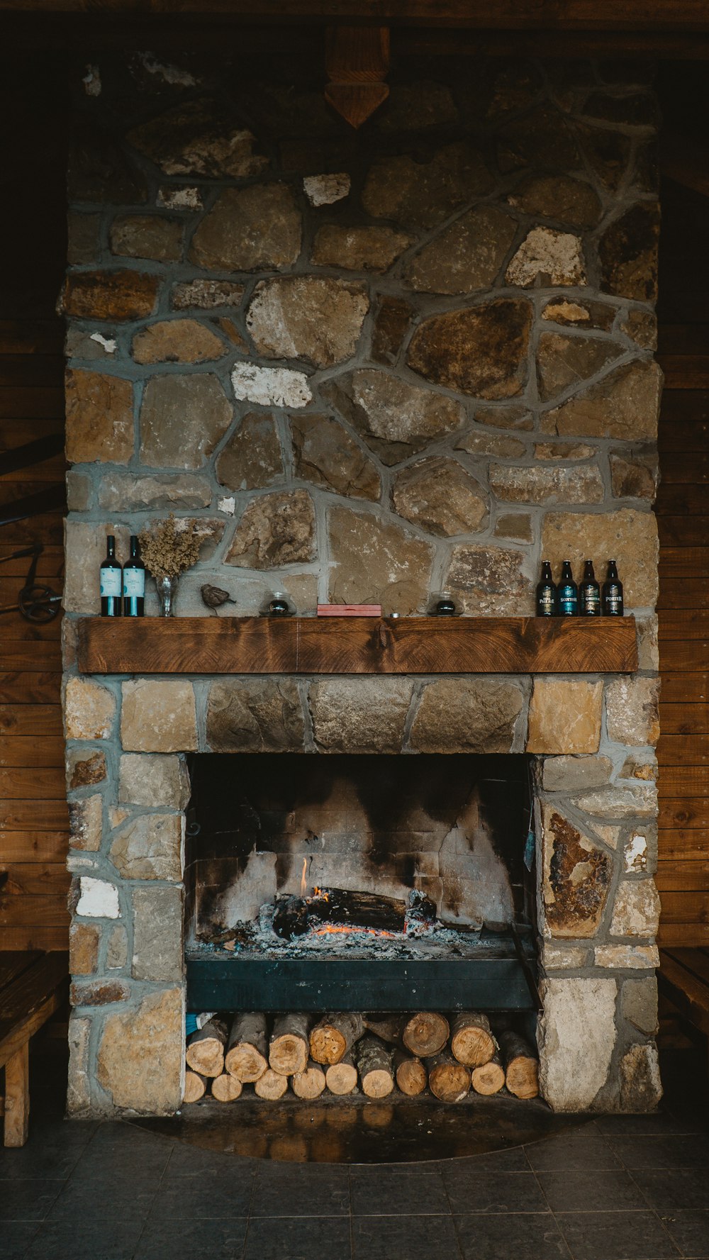 brown brick fireplace with bottles on top