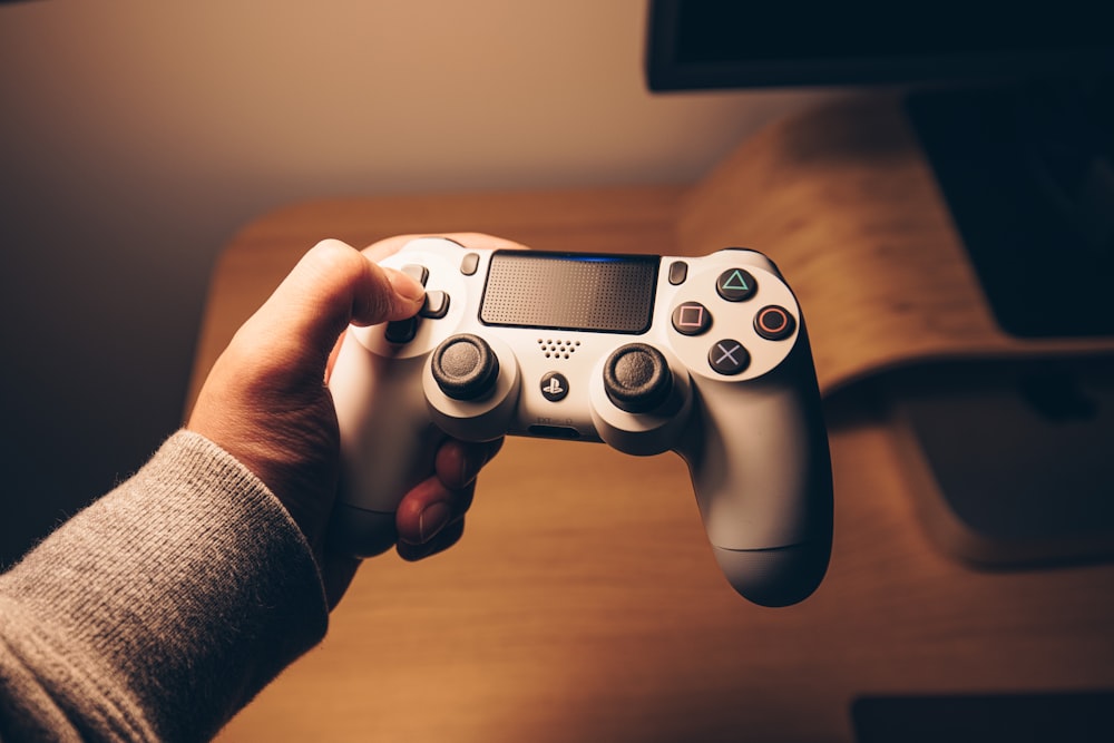 person holding black sony ps 4 controller