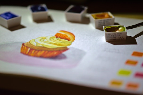 A watercolor artwork inspired by everyday objects like fruits and cups on a table.