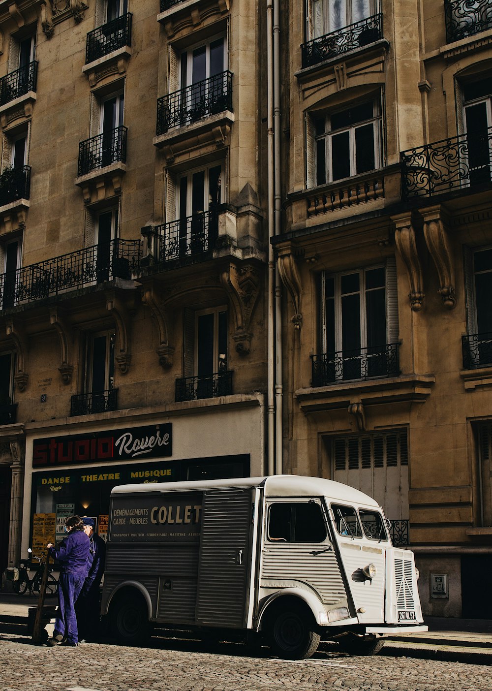 white van parked beside building during daytime