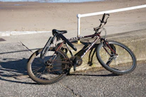 Vintage bicycle resting against a sunlit sandy path along the Adriatic coast.