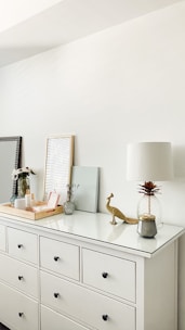 A cozy farmhouse white dresser with rustic metal handles in a sunlit room.