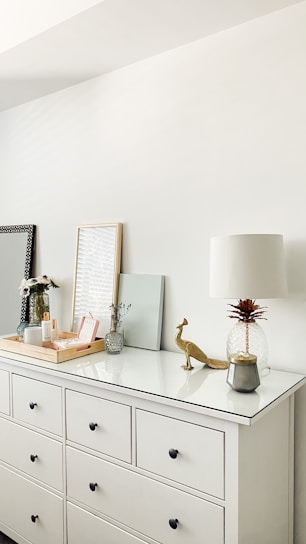 A cozy farmhouse white dresser with rustic metal handles in a sunlit room.