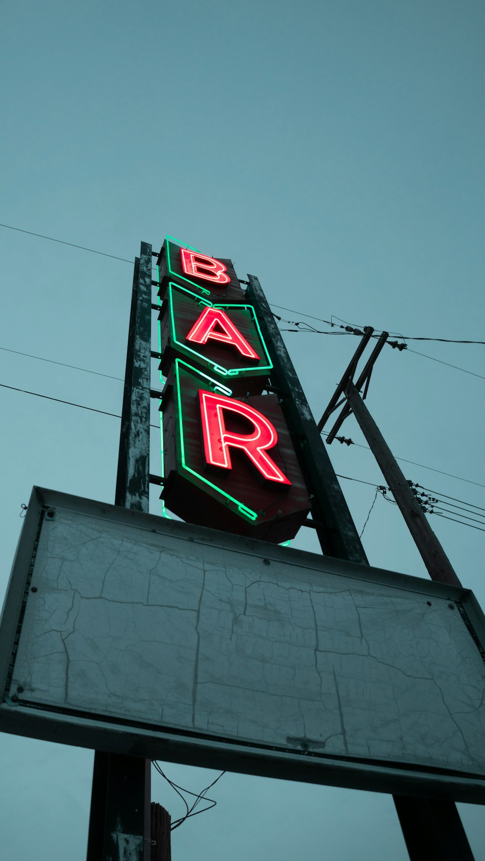 a neon sign for a bar on the side of a building