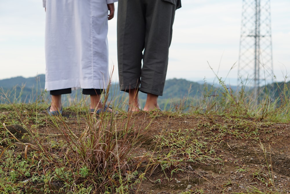 낮에 푸른 잔디밭을 걷는 동안 손을 잡고 있는 남자와 여자