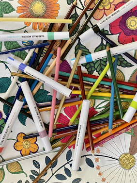 A bright, playful scene showing a child happily coloring inside a printable coloring book filled with animals and nature themes.