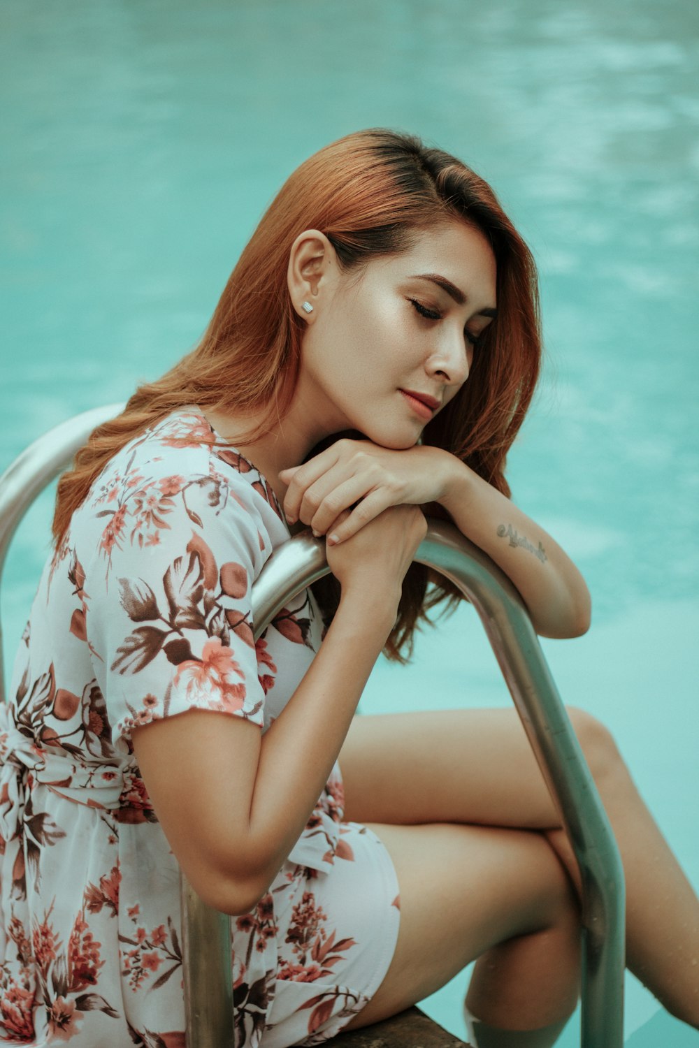 woman in white red and blue floral dress sitting on chair