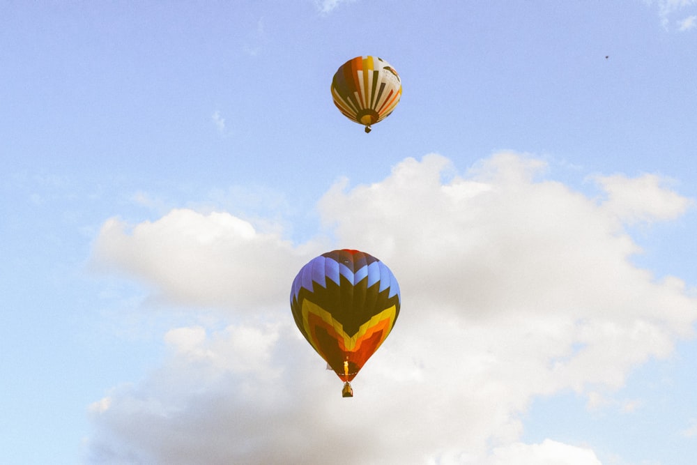montgolfière jaune et verte dans les airs sous les nuages blancs et le ciel bleu pendant