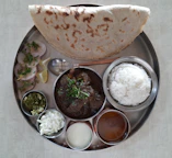 Freshly cooked Indian meal served on a traditional plate, garnished with herbs.