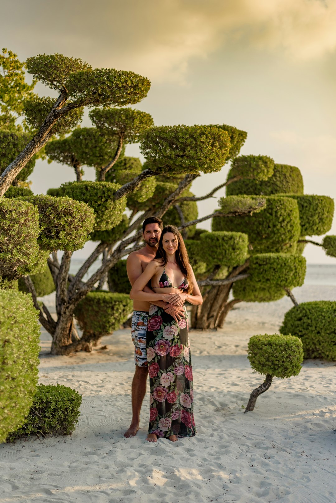 woman in blue and white floral dress standing on beach during daytime