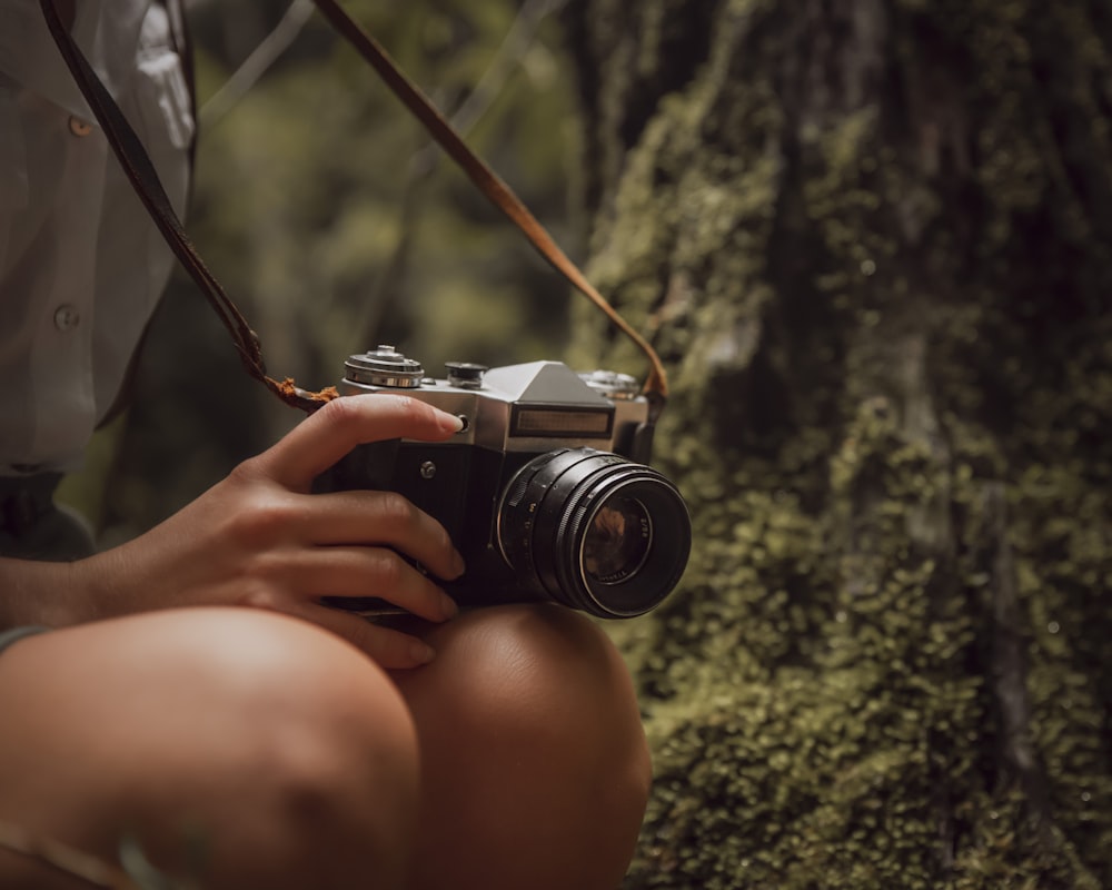 person holding black and silver dslr camera