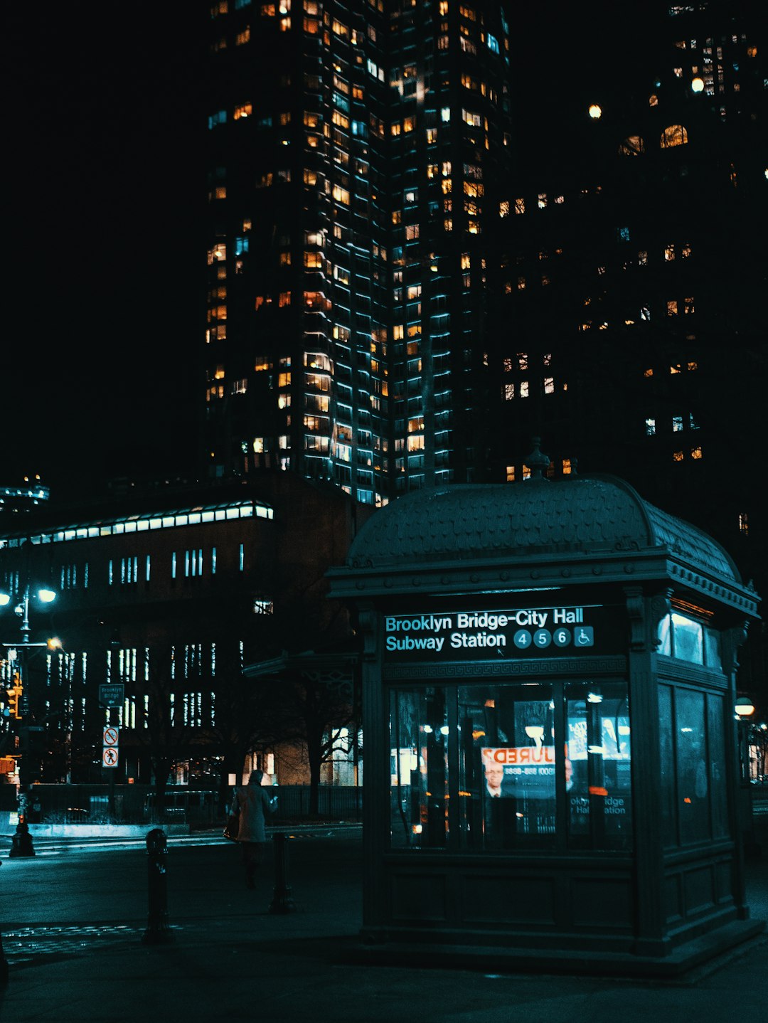 people walking on sidewalk near building during night time