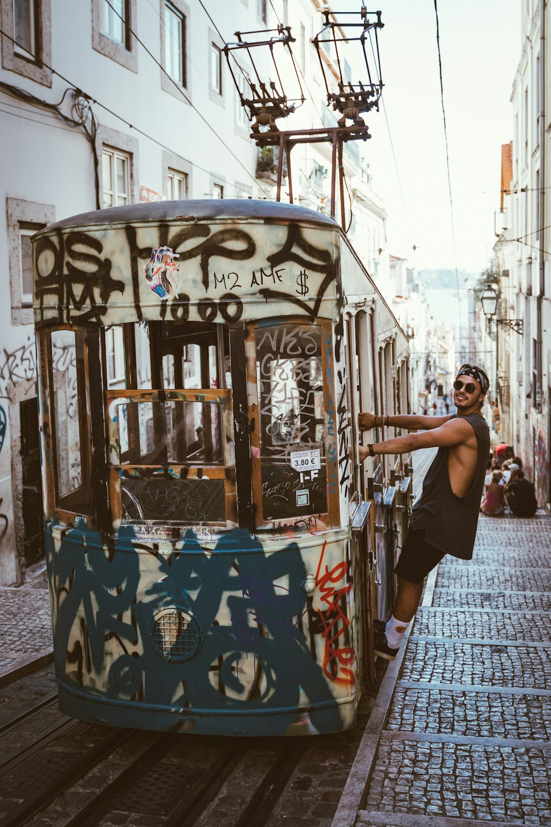 woman in black tank top standing beside blue and white floral train during daytime