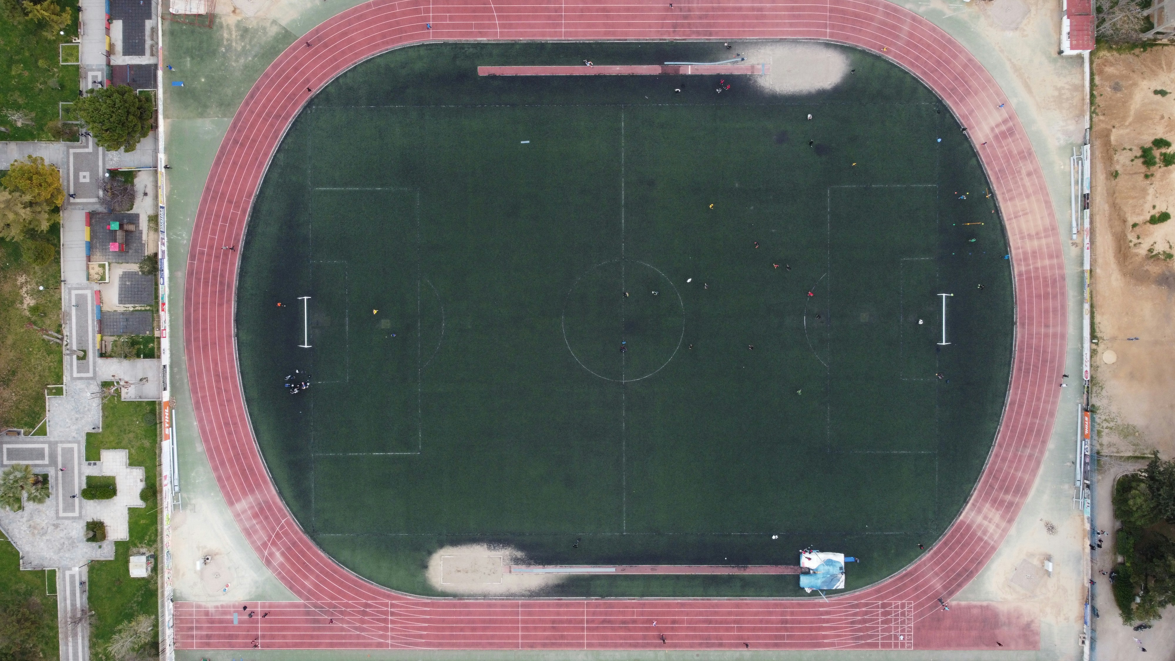 Aerial view of a sports court highlighting its location amidst community buildings