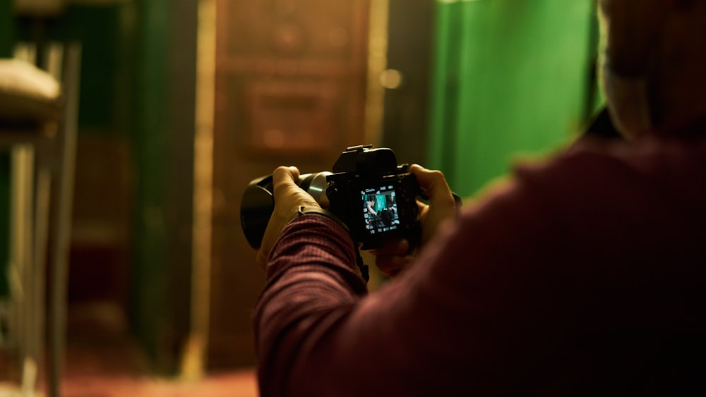 person holding black dslr camera