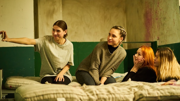 A group selfie of young women smiling and relaxed, capturing the joy of the slumber party experience.