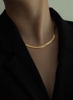 woman in black blazer wearing gold necklace