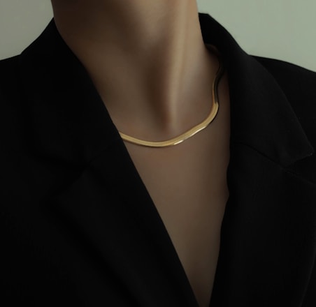 woman in black blazer wearing gold necklace