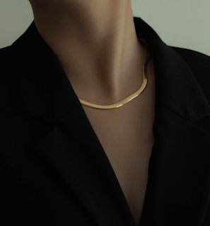 woman in black blazer wearing gold necklace