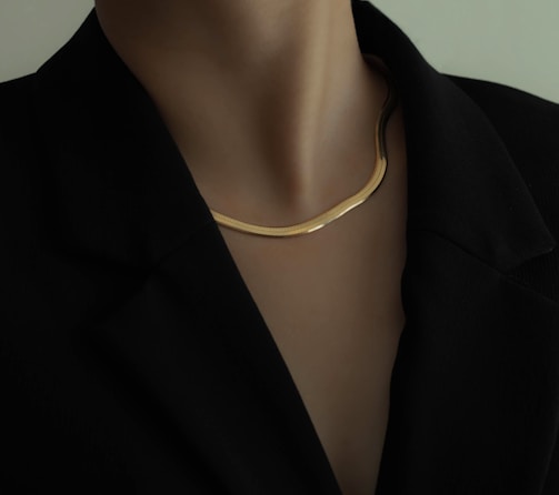 woman in black blazer wearing gold necklace
