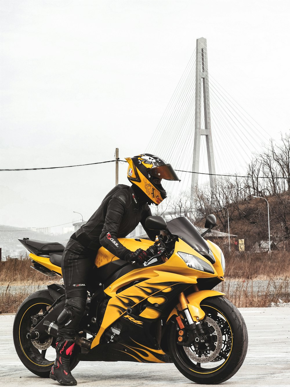 man in black and yellow jacket riding yellow and black sports bike