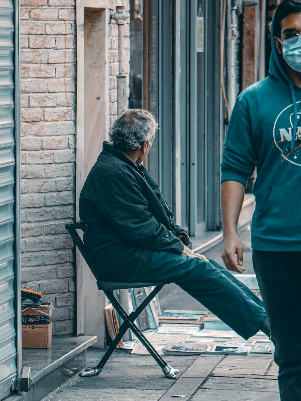 man in green crew neck t-shirt and blue denim jeans standing beside man in green