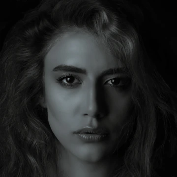 A close-up portrait of a person with expressive eyes against a simple background.