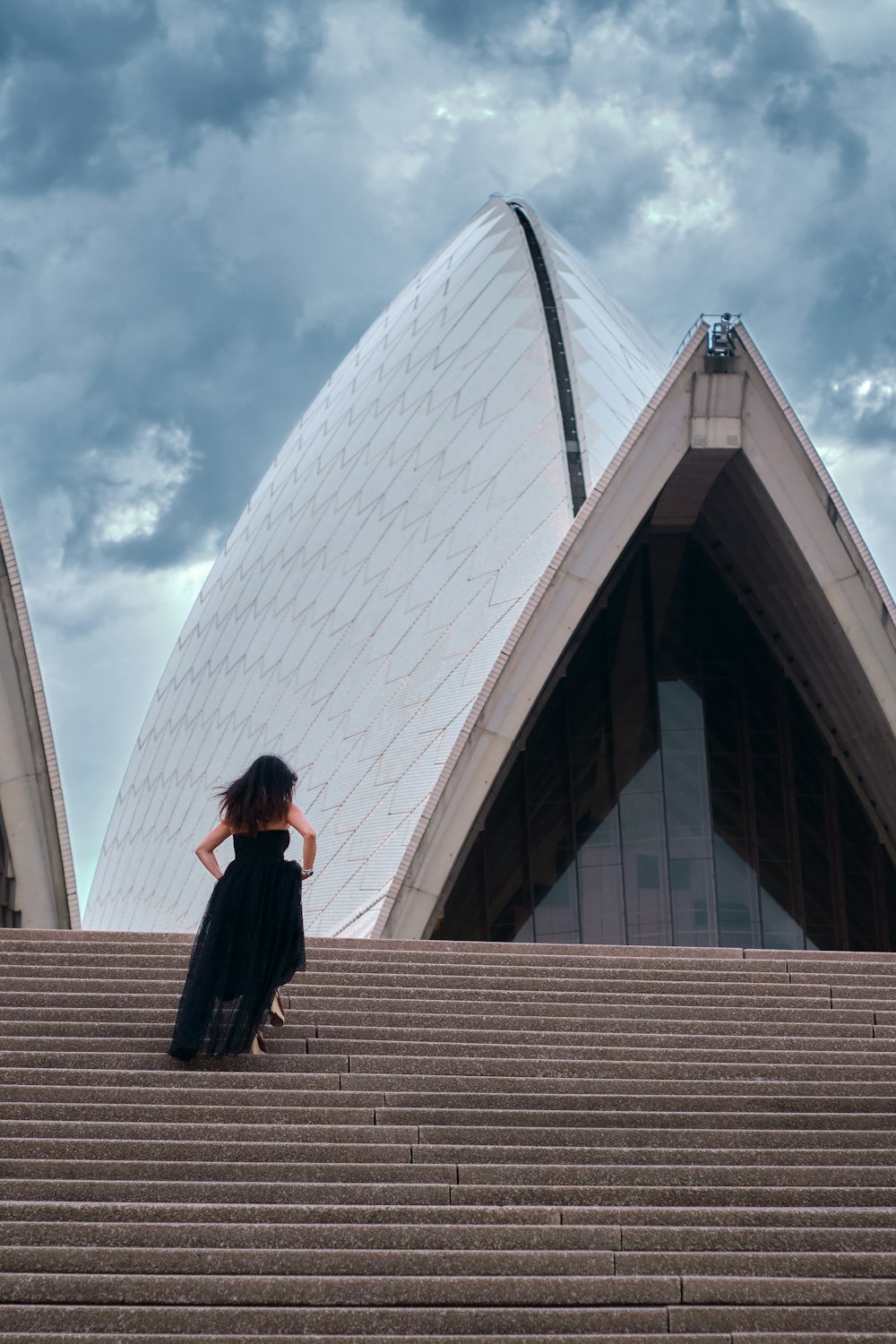 woman in black jacket and black pants standing on stairs