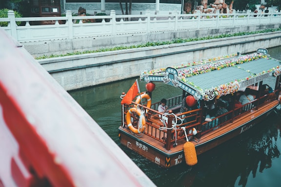 Colorful trajinera boat floating on Xochimilco canal with vibrant flowers and passengers enjoying the ride