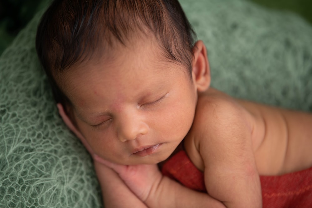 topless baby lying on bed