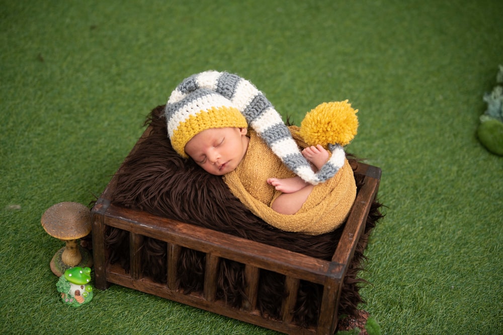 girl in brown sweater lying on brown wooden bench