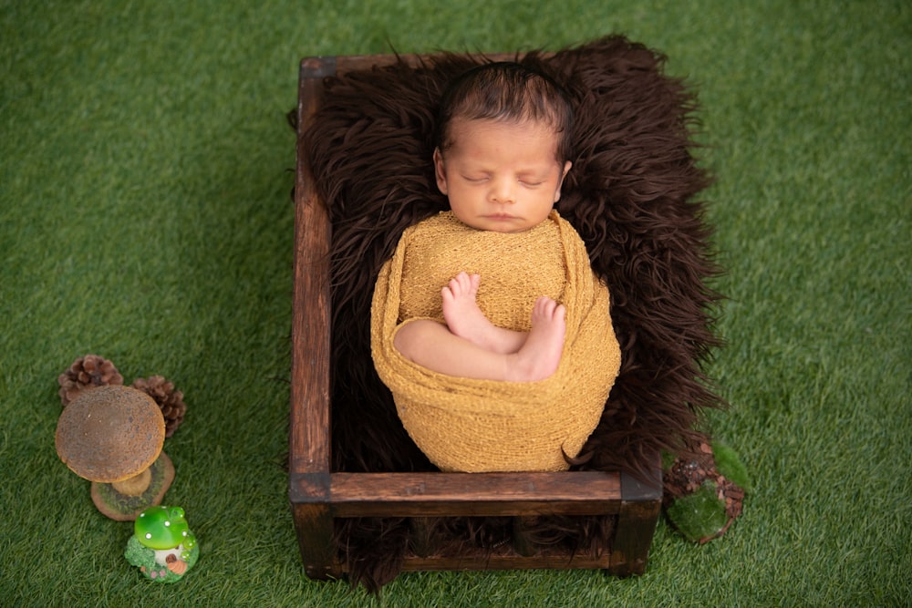 girl in yellow sweater sitting on brown wooden box