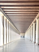 white and brown hallway with white columns