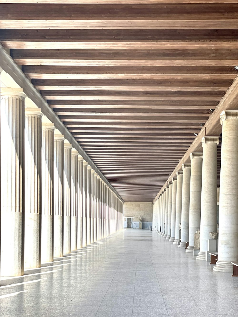 white and brown hallway with white columns