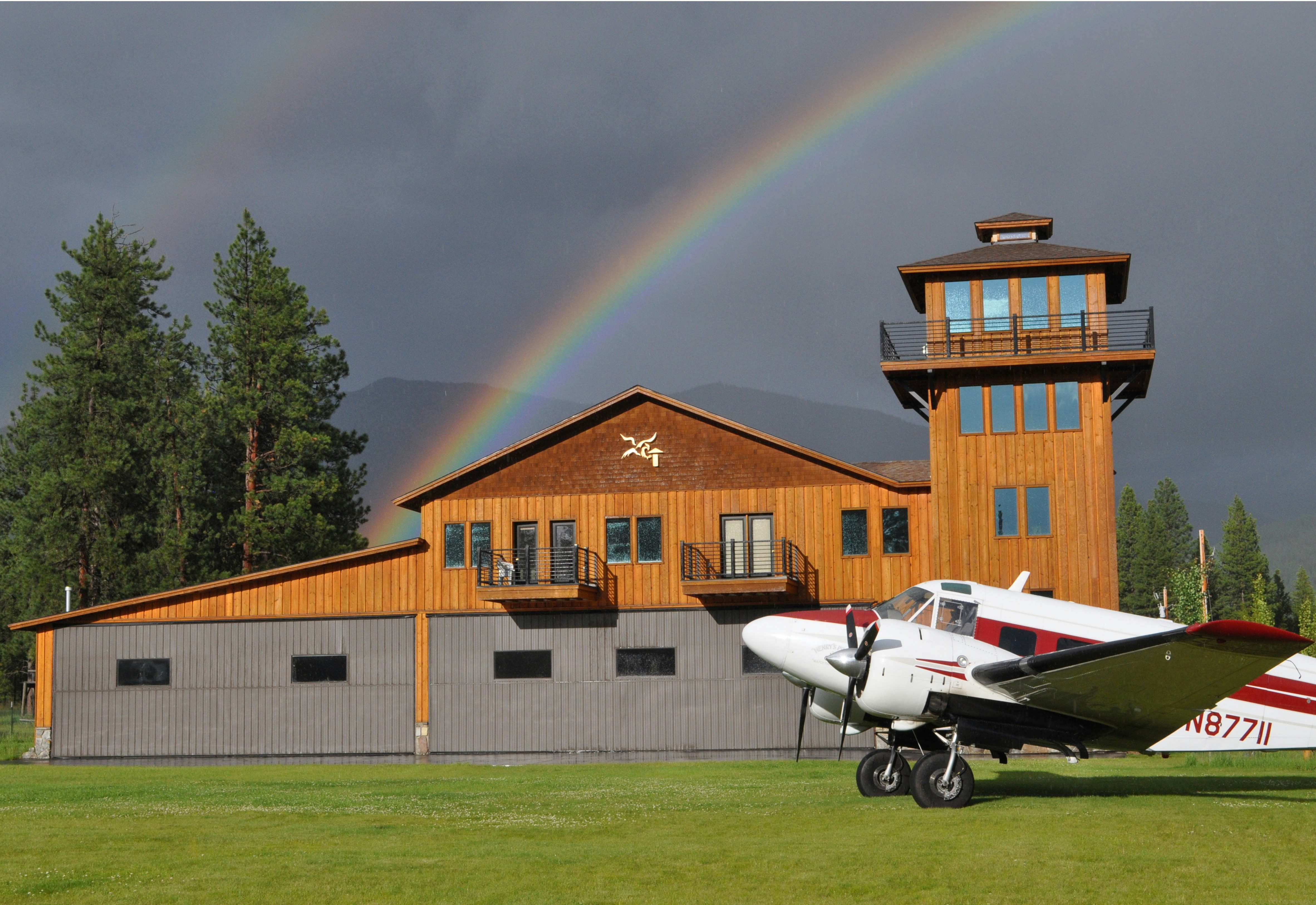 white airplane on green grass field near brown concrete house during daytime
