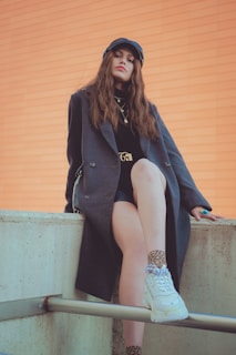 woman in black blazer sitting on concrete bench
