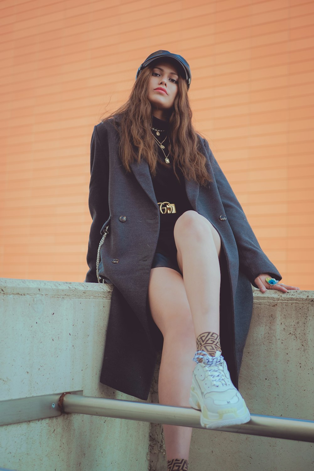 woman in black blazer sitting on concrete bench