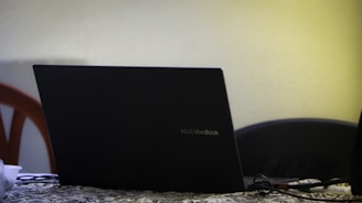 black lenovo laptop computer on black and white textile