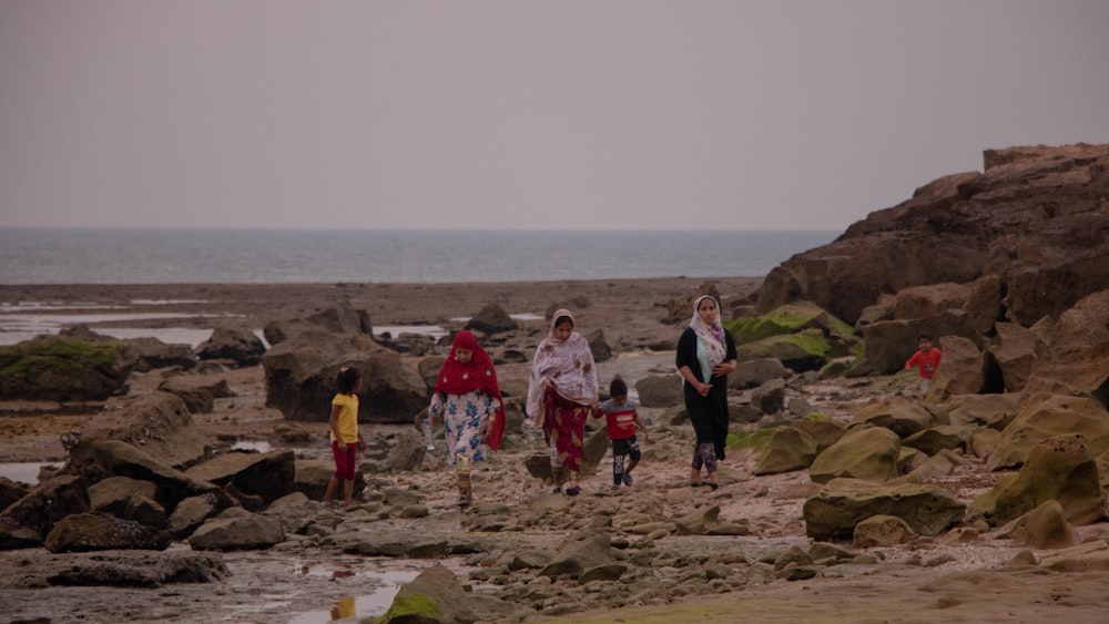 group of people standing on gray sand during daytime