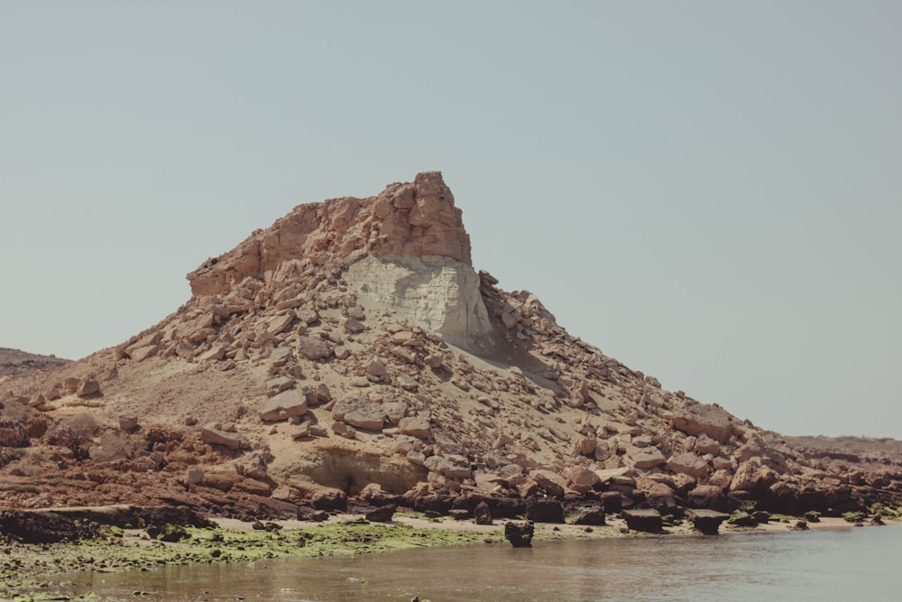 brown rock formation near body of water during daytime