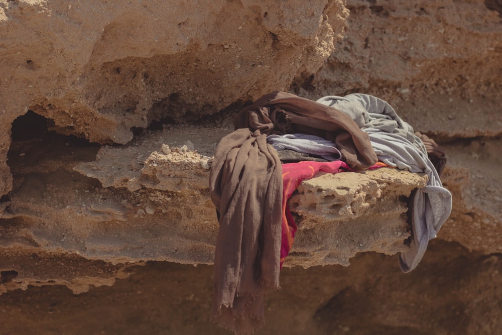 man lying on brown rock