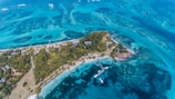 An aerial shot of pristine waters surrounding a private island resort.