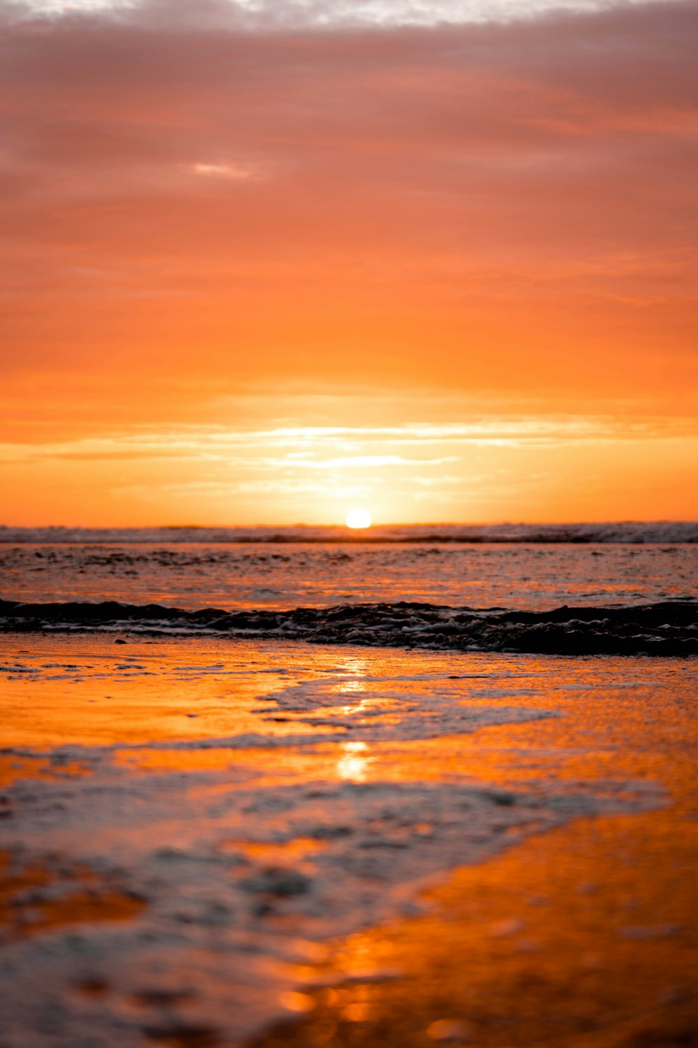 sea waves crashing on shore during sunset