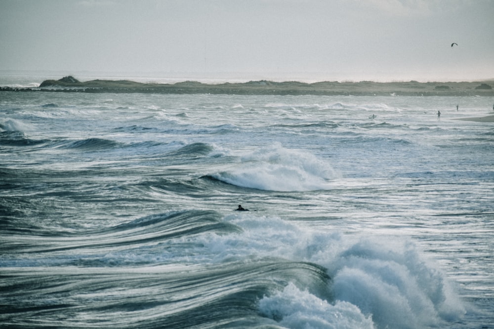 ocean waves under white sky during daytime