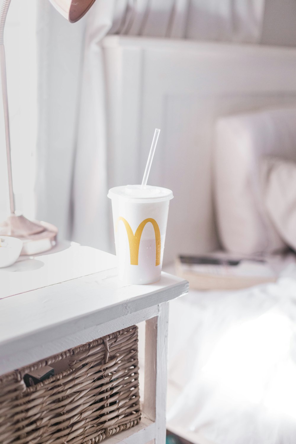 white and yellow disposable cup on white table